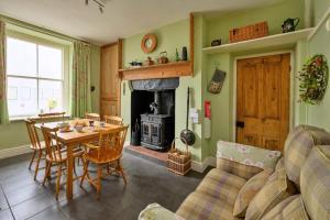 a living room with a table and a fireplace at Finest Retreats - Bod Gwynedd in Penmachno