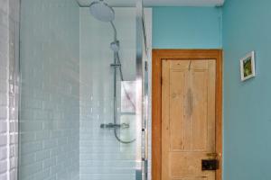 a shower with a wooden door in a bathroom at Finest Retreats - Bod Gwynedd in Penmachno +22 photos