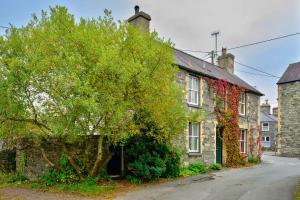 an old brick house with a tree next to a street at Finest Retreats - Bod Gwynedd in Penmachno