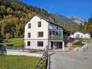 una gran casa blanca con muchas ventanas en Ferienwohnung Palidi, en Ausserwald