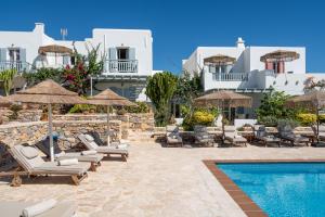 a resort with a swimming pool and chairs and buildings at Aeolos Hotel in Koufonisia