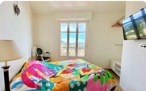 - une chambre avec un lit coloré et une fenêtre dans l'établissement Nice 2 Pièces Vu mer Balcon, à Nice