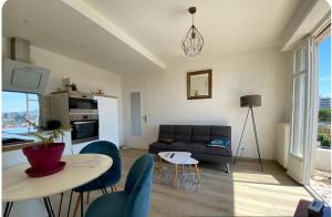 un salon avec un canapé, une table et des chaises dans l'établissement Nice 2 Pièces Vu mer Balcon, à Nice