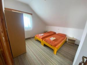 a bedroom with a bed with orange sheets and a window at Pansion Tomas Kupres in Kupres