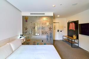 a bedroom with a white bed and a wall with graffiti at Hotel Melibea by gaiarooms in Salamanca