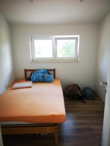 een slaapkamer met een bed met blauwe lakens en een raam bij Haus Martha 