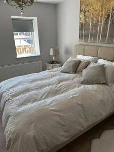 a large bed in a bedroom with a window at Creggan Deveskey Homestead in Carrickmore