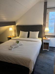 a bedroom with a large white bed with two lamps at Le Point du jour in Saint-Cergue