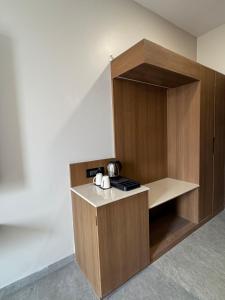 a kitchen with a wooden cabinet with a coffee maker at Modern Hotel Restaurant and Bar in Mathura
