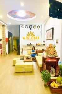 a woman sitting on a couch in a living room at Khách Sạn An Chi in Ho Chi Minh City