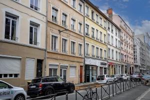 Una calle de la ciudad con coches aparcados en la calle. en L'atelier de Charpennes, en La Celle-sous-Gouzon