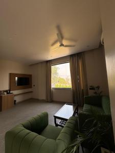 a living room with a green couch and a television at Modern Hotel Restaurant and Bar in Mathura