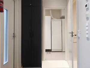 a hallway with a black door and a white bathroom at Villa Luppo A in Syöte