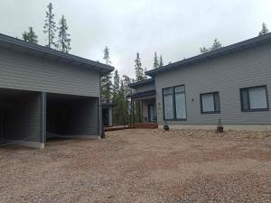 a house with a garage next to a building at Villa Luppo A in Syöte