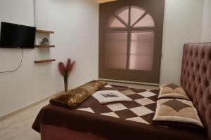 a bed in a room with a window and a couch at فندق السعادة in Al Qarn