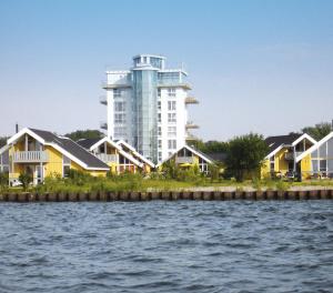Blick auf ein Gebäude aus dem Wasser in der Unterkunft Ferienpark Müritz in Rechlin