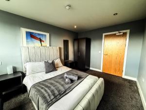 a bedroom with a large bed and a wooden door at Modern City Centre Apartment - 2BR - Sleeps 8 - Parking & River Views in Newcastle upon Tyne