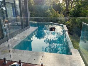 a swimming pool in a house with blue water at Hilltop Getaway in Ocean View