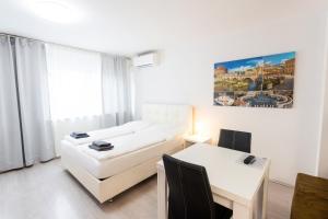 a bedroom with a bed and a desk and a table at 305 Berlin, Studio Apartment, 38m2 2-4 Pers in Klagenfurt