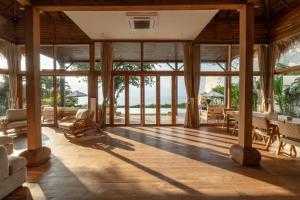 an open living room with large glass windows at Villa Selatan in Jimbaran