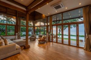 a living room filled with furniture and large windows at Villa Selatan in Jimbaran