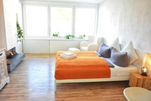 a bedroom with a bed with an orange blanket at Apartment mitten in Rosenheim in Rosenheim