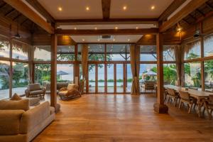 a living room with a table and chairs and windows at Villa Selatan in Jimbaran +26 photos