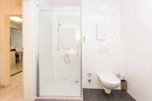 a white bathroom with a shower and a toilet at 305 Berlin, Studio Apartment, 38m2 2-4 Pers in Klagenfurt +36 photos