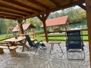 a patio with chairs and a picnic table and a pavilion at Vikendica Krupa na Vrbasu in Banja Luka +26 photos