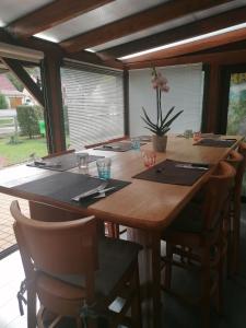 a large wooden table with chairs and a vase of flowers at chambres d hôtes chez Isabelle in La Ferté-Saint-Cyr