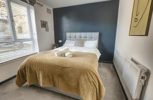 a bedroom with a large bed with a yellow blanket at Comfy 1BR Apt, Self Check In, Free Parking by The Davis Collective in Derby