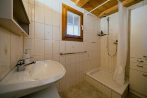 a bathroom with a sink and a shower and a tub at Mountain Apartment - Hot Tub & Sunset Views in Axalp