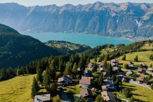 an aerial view of a village on a hill with a lake at Mountain Apartment - Hot Tub & Sunset Views in Axalp