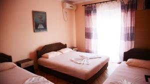a small bedroom with two beds and a window at Apartaments A4 in Ulcinj