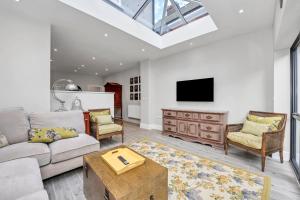 a living room with a couch and a tv at Flat 1, 119 Northgate St - luxury 2 bedroom apartment apartment close to the town centre with paid parking close by in Bury Saint Edmunds