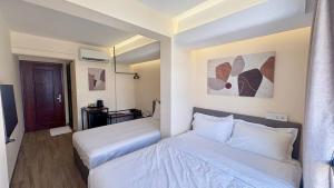 Una habitación de hotel con dos camas y un espejo. en The Guesthouse By SH, en Phnom Penh