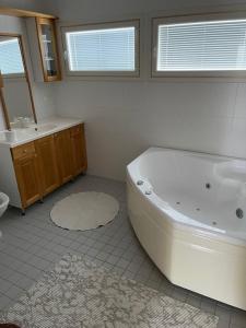 een badkamer met een groot bad en een wastafel bij Villa Koivurinne in Äänekoski +9 foto's
