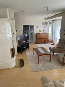 een woonkamer met een tafel en een piano bij Villa Koivurinne in Äänekoski
