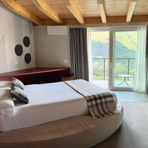 a bedroom with a large bed and a large window at Miramontino Mountain Suite in Rota d'Imagna