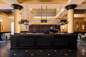 a bar in a hotel lobby with wine glasses at JAZ Lamaya Resort in Coraya Bay