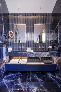 a bathroom with two sinks and two mirrors at MACAM Hotel in Lisbon