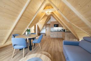 a living room with a table and blue chairs at Apartamenty Koziniec Lux in Czarna Góra
