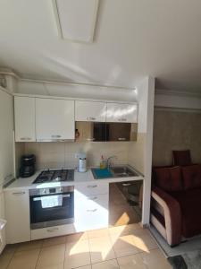 Una cocina con gabinetes blancos y un horno de estufa. en Fiald-Apartament Nou, en Bacău