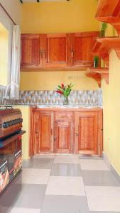 a kitchen with wooden cabinets and a tile floor at Garden House in Huye