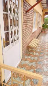 a wooden bench sitting next to a brick building at Garden House in Huye