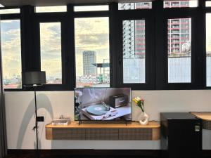 a tv sitting on a table in a room with windows at MAIA Hotel & Apartment Danang in Danang
