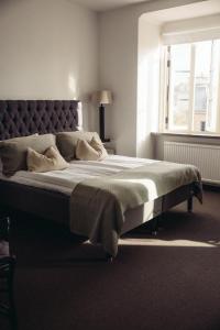a large bed in a bedroom with a window at Varbergs Kusthotell in Varberg