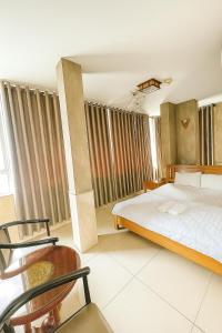 a bedroom with a bed and a chair at Sài Gòn Hotel Bình Tân in Ho Chi Minh City