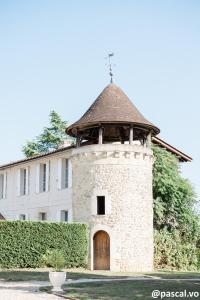 a tower with a door in front of a building at Chambres d'hôtes du Château de Seguin in Lignan-de-Bordeaux