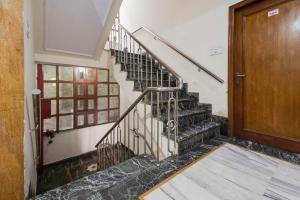 a staircase in a house with a wooden door at Hotel New Center Point in Jaipur